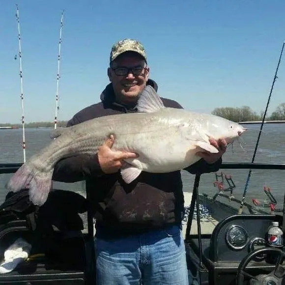 a happy angler holding a huge catfish