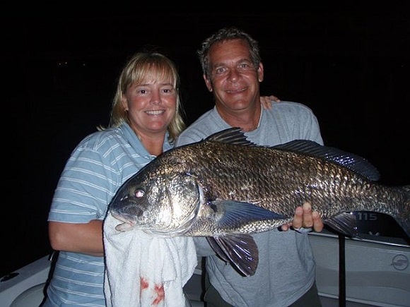 a couple fishing for big black drum at night