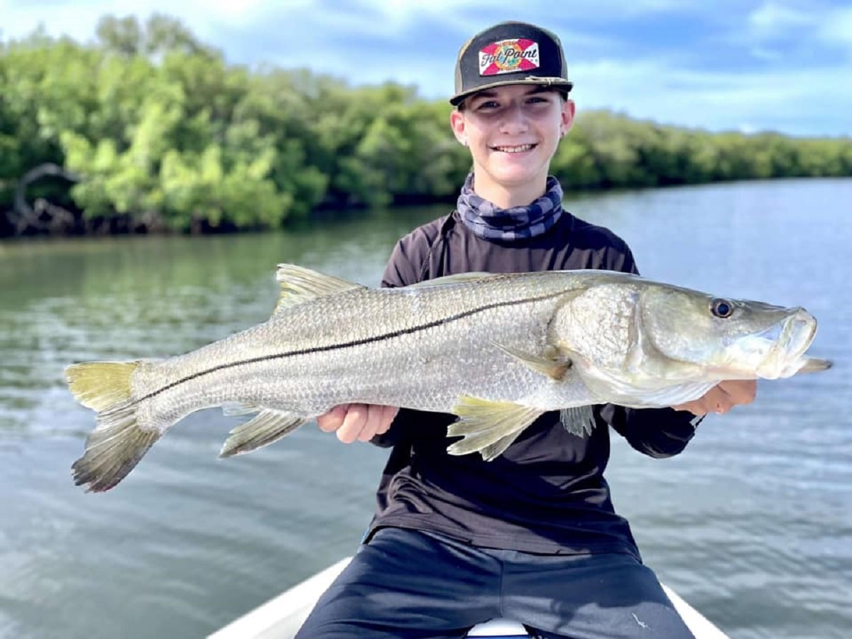 a happy angler in Florida holding a giant snook