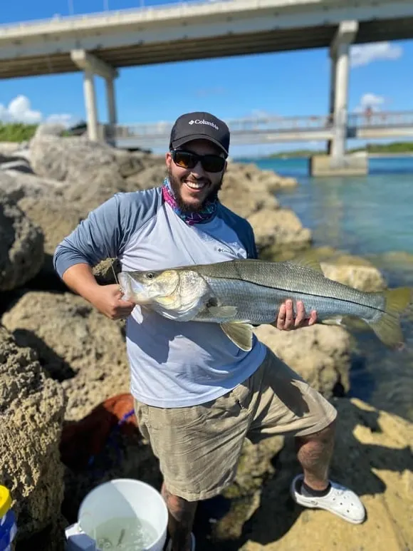 a happy angler holding a trophy-sized snook